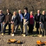 Individuals posing with shovels and toy trucks